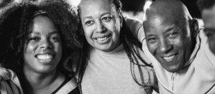 Happy african family smiling on camera at home garden party duri